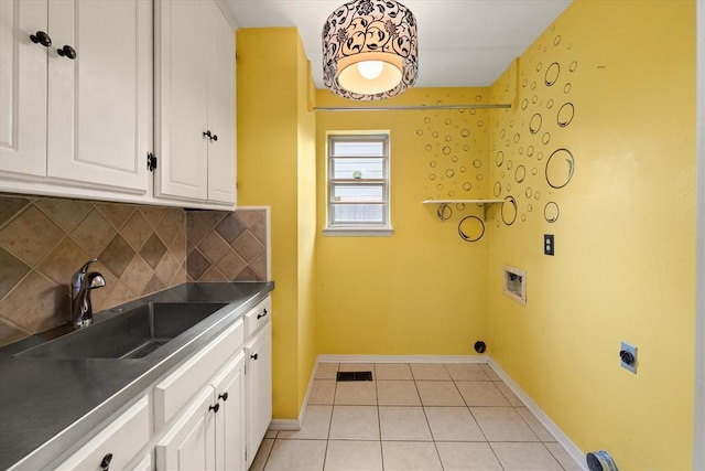laundry area featuring visible vents, light tile patterned flooring, baseboards, electric dryer hookup, and a sink