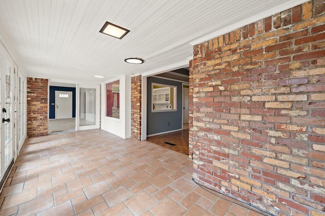 interior space with brick wall and wooden ceiling