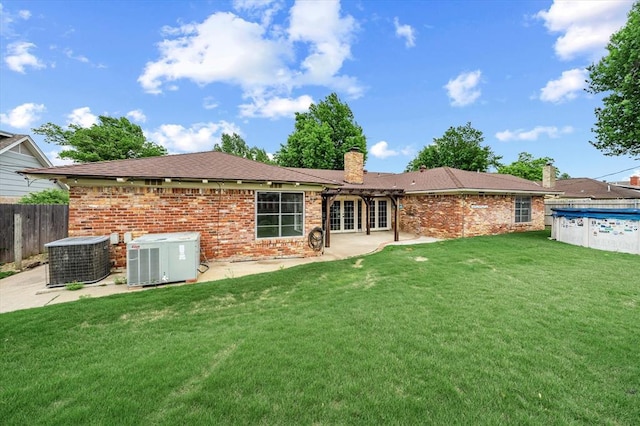 back of property featuring fence, a chimney, central AC, and a patio area