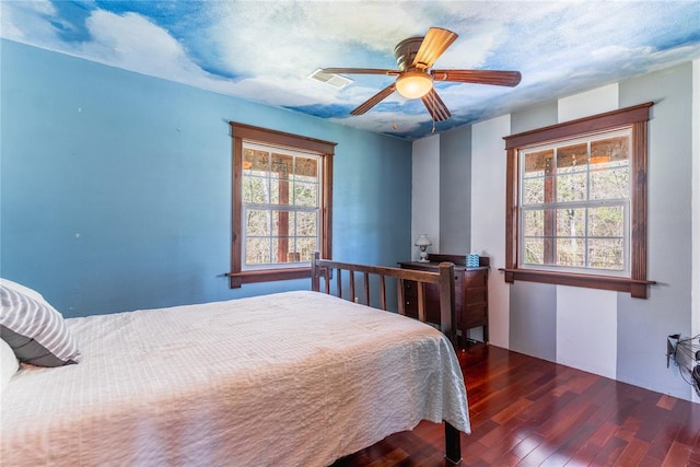 bedroom with visible vents, a ceiling fan, and wood finished floors