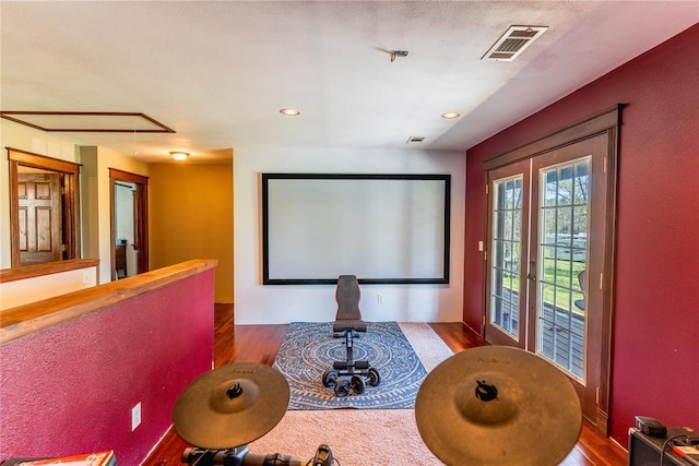 cinema with recessed lighting, visible vents, and wood finished floors