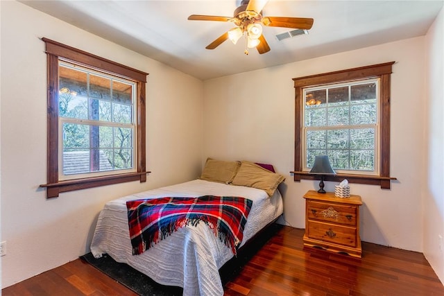 bedroom featuring ceiling fan, wood finished floors, and visible vents
