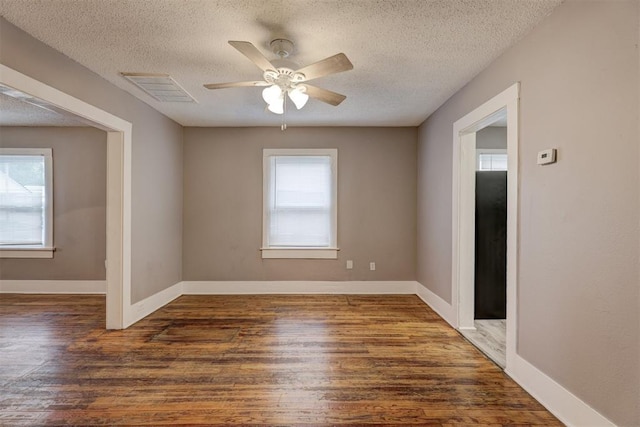 unfurnished room featuring visible vents, a ceiling fan, a textured ceiling, and wood finished floors