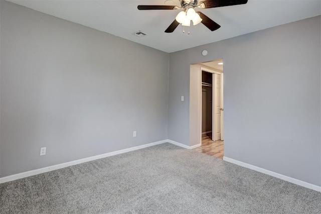 spare room featuring ceiling fan, light colored carpet, baseboards, and visible vents