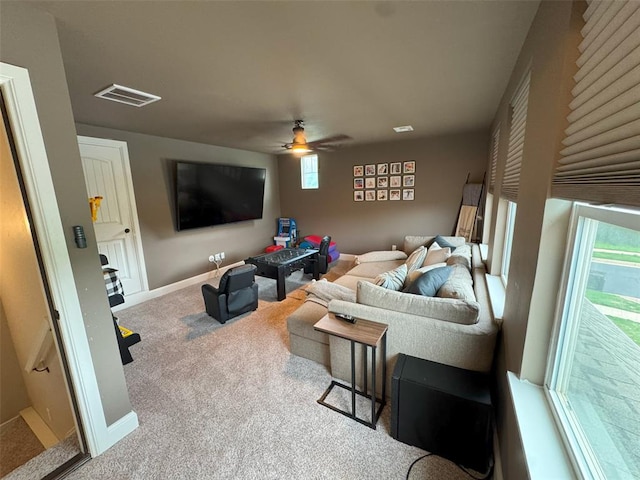carpeted living area featuring visible vents, ceiling fan, and baseboards