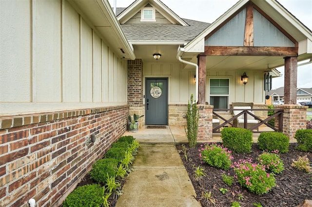 2201 Creek Side Cir, Moore, OK 73160 - doorway to property with roof with shingles, board and batten siding, a porch, and brick siding