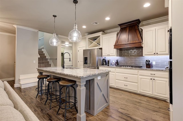 2201 Creek Side Cir, Moore, OK 73160 - kitchen featuring a sink, custom range hood, appliances with stainless steel finishes, tasteful backsplash, and white cabinets