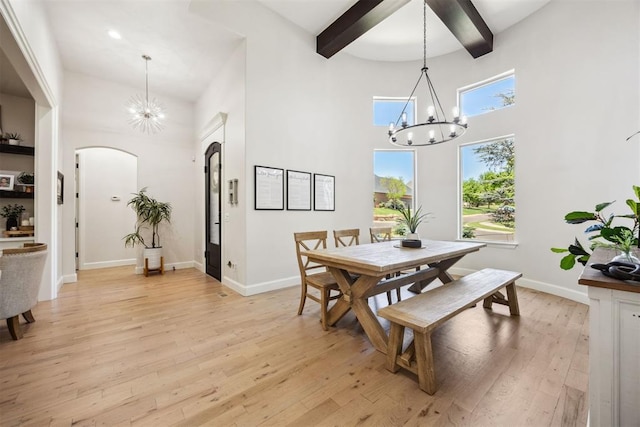 dining area with arched walkways, a high ceiling, and a notable chandelier