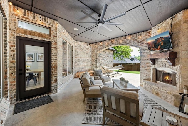 view of patio with ceiling fan and an outdoor living space with a fireplace
