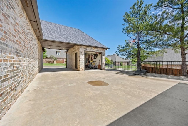 view of patio with fence, an outbuilding, and a garage