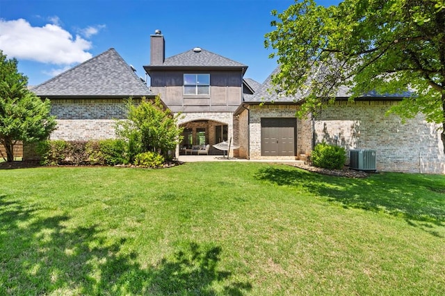 rear view of house with a lawn, brick siding, central air condition unit, and a chimney