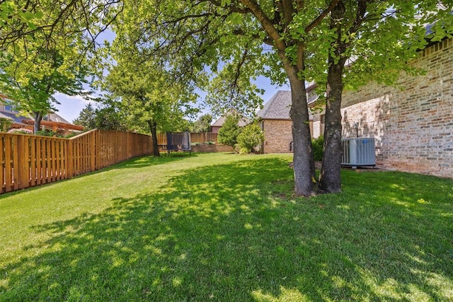 view of yard with a fenced backyard and central air condition unit