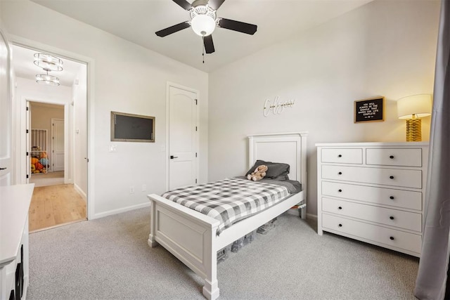bedroom with a ceiling fan, baseboards, and light colored carpet