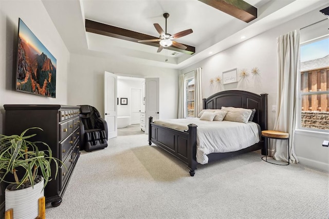 bedroom with a raised ceiling, multiple windows, and light carpet