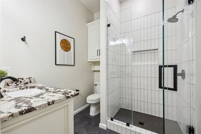 full bathroom with vanity, toilet, baseboards, and a stall shower