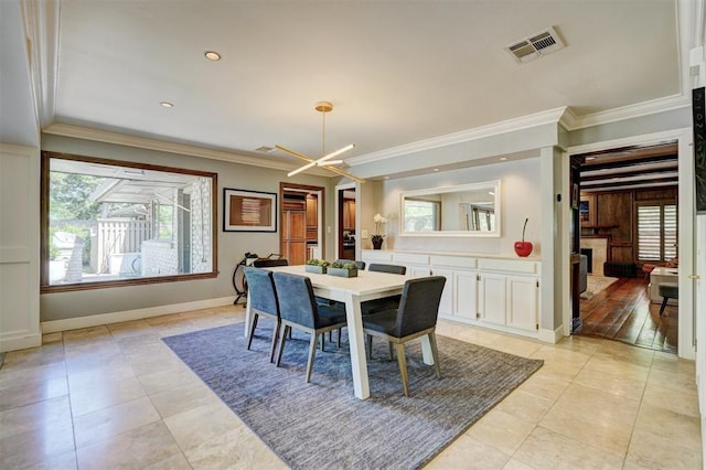 dining space with crown molding, baseboards, visible vents, and plenty of natural light