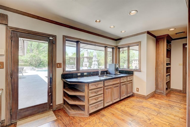 kitchen featuring crown molding, open shelves, light wood-style floors, recessed lighting, and a sink