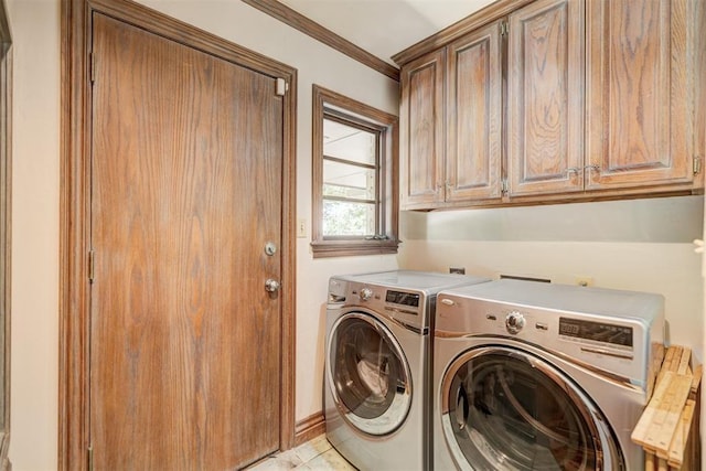 clothes washing area with crown molding, washer and clothes dryer, and cabinet space