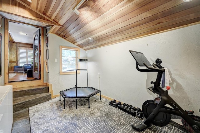 workout area with baseboards, a textured wall, wood ceiling, and lofted ceiling