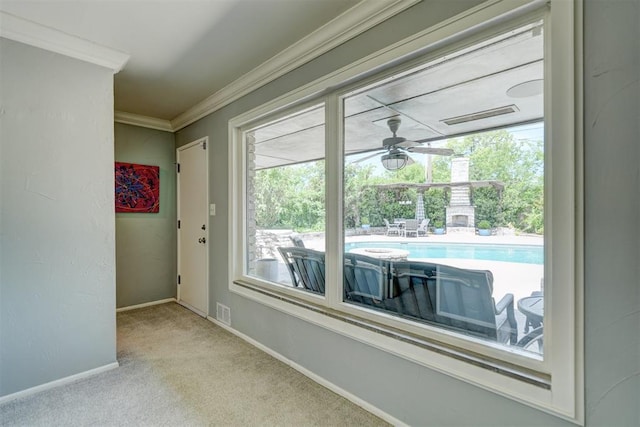 interior space with crown molding, baseboards, ceiling fan, and visible vents
