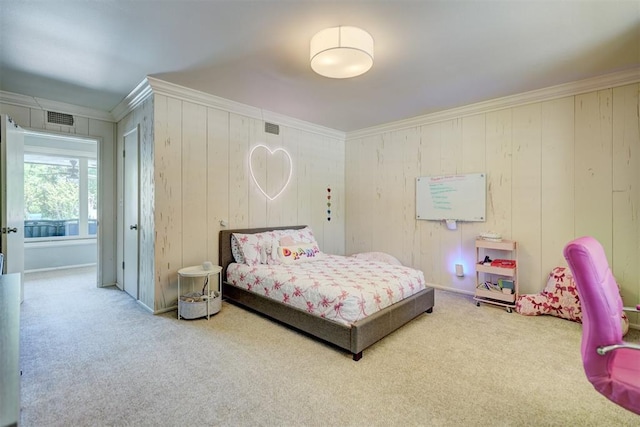 carpeted bedroom with ornamental molding, wood walls, and visible vents