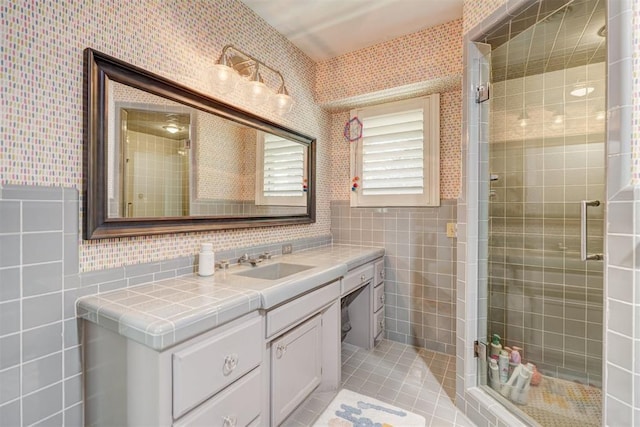 full bathroom featuring tile patterned flooring, vanity, tile walls, wallpapered walls, and a shower stall