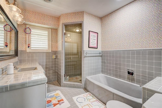 bathroom featuring a garden tub, tile walls, tile patterned flooring, a shower stall, and wallpapered walls