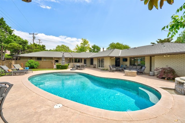 view of swimming pool featuring fence, a fenced in pool, a fire pit, and a patio area
