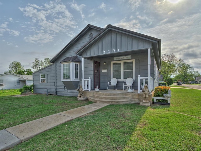 bungalow-style house with board and batten siding, a porch, and a front lawn