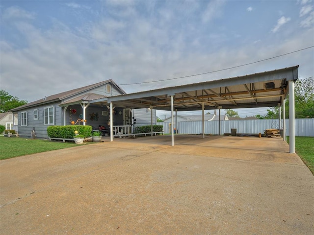 view of vehicle parking with fence and concrete driveway