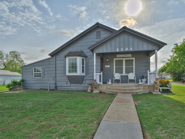 bungalow-style home featuring board and batten siding, a porch, and a front lawn