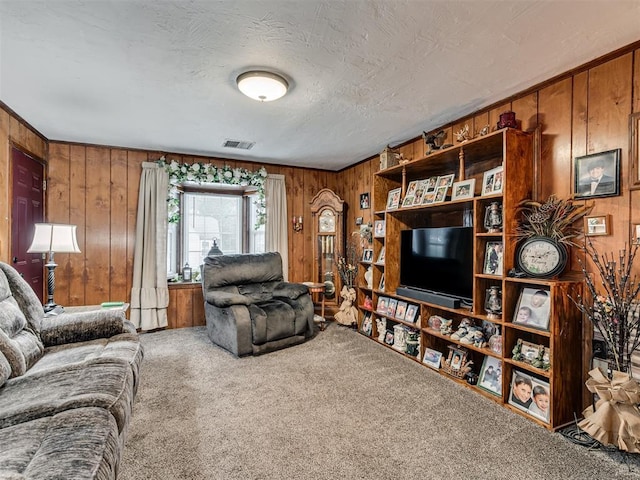 living room featuring carpet, wood walls, and visible vents