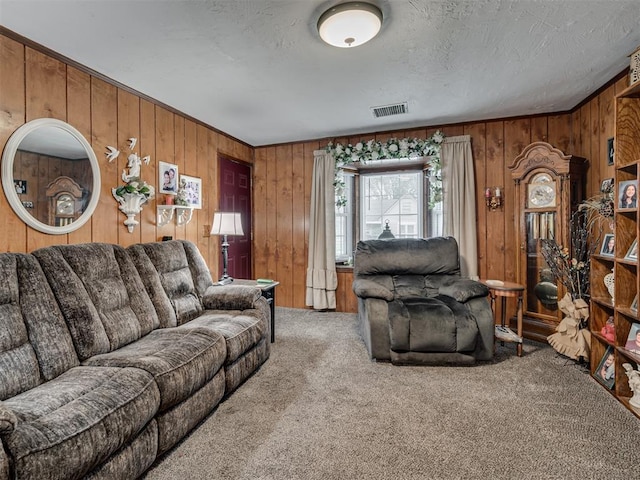 carpeted living area with wooden walls and visible vents