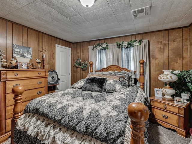 bedroom featuring wood walls and visible vents