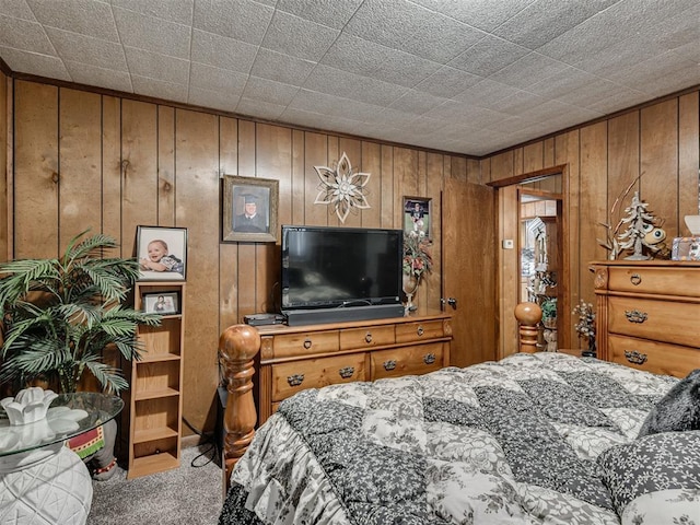 carpeted bedroom featuring wooden walls
