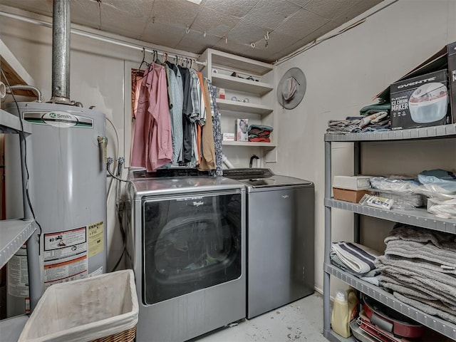 clothes washing area featuring independent washer and dryer, laundry area, and water heater