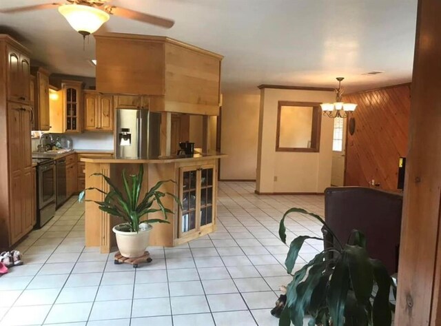 kitchen with appliances with stainless steel finishes, a center island, wooden walls, glass insert cabinets, and light tile patterned flooring