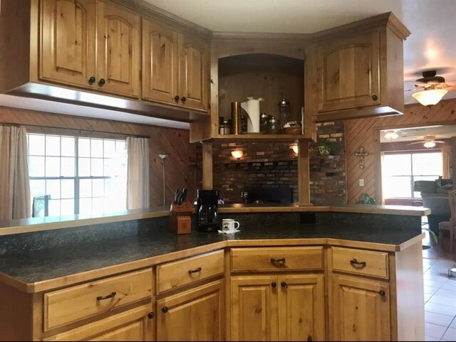 kitchen featuring dark countertops, a ceiling fan, light tile patterned flooring, and a wealth of natural light