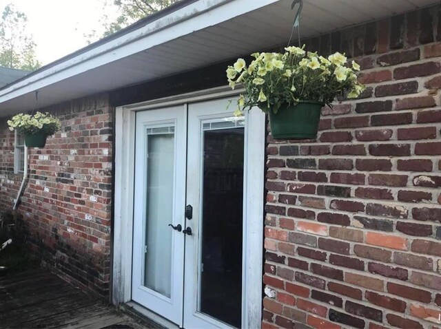 doorway to property featuring brick siding and french doors