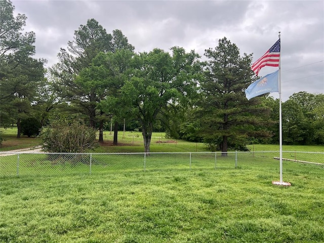 view of property's community featuring a lawn and fence