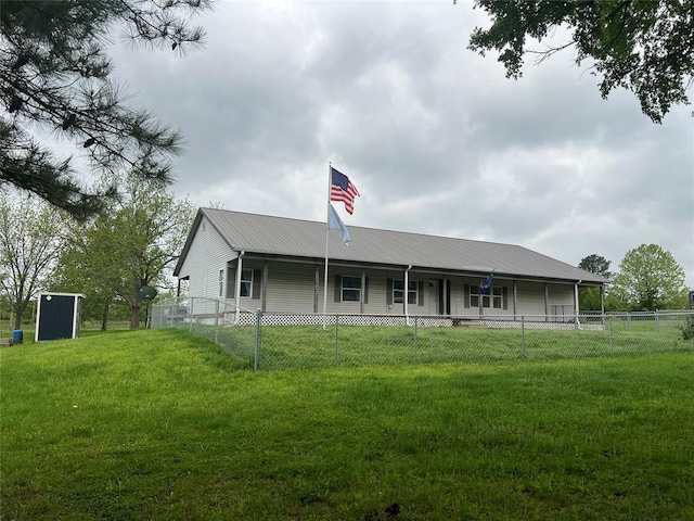 view of front facade featuring metal roof, fence private yard, and a front lawn
