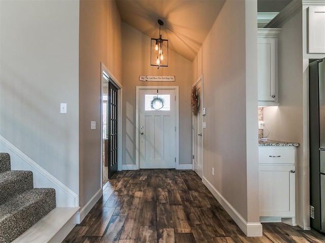 entrance foyer featuring stairway, baseboards, lofted ceiling, and dark wood-type flooring