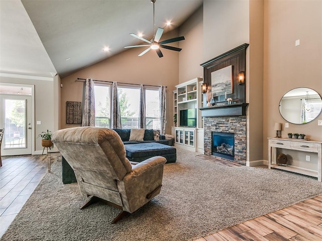 living room featuring baseboards, ceiling fan, high vaulted ceiling, and a fireplace