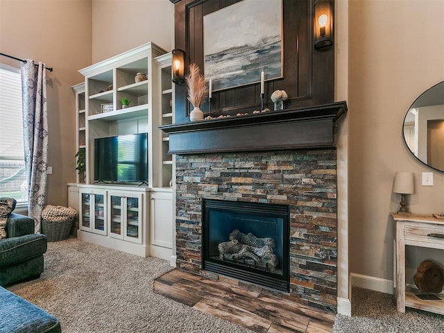 living area with baseboards and a fireplace
