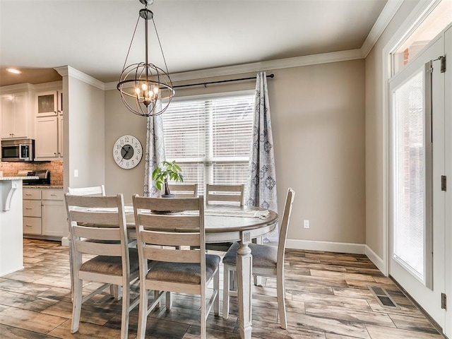 dining area with plenty of natural light, ornamental molding, light wood-type flooring, and visible vents