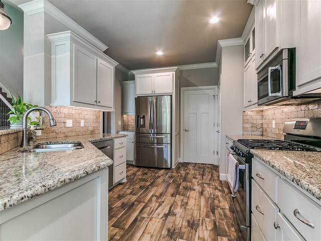 kitchen with ornamental molding, light stone counters, a sink, appliances with stainless steel finishes, and backsplash