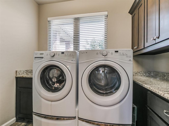 laundry room featuring cabinet space, washer and clothes dryer, and dark wood-type flooring