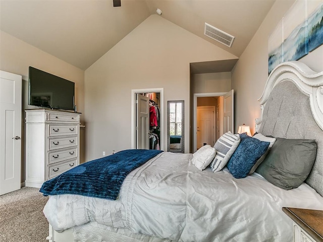 carpeted bedroom with visible vents, a walk in closet, vaulted ceiling, and a closet
