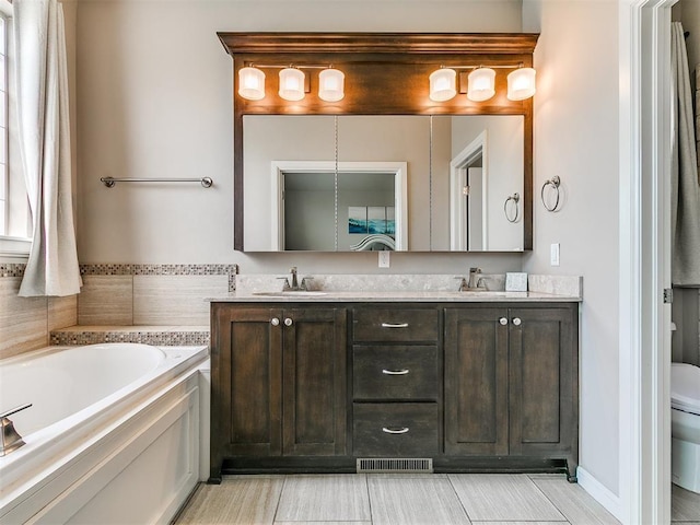 full bath featuring double vanity, a garden tub, visible vents, a sink, and toilet