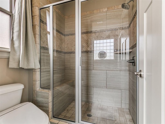 bathroom with a shower stall and toilet